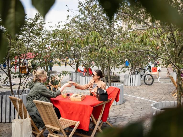 Menschen beim Picknick auf einem Platz.